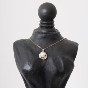 Collar de perla en el centro con una estela dorada de zirconias